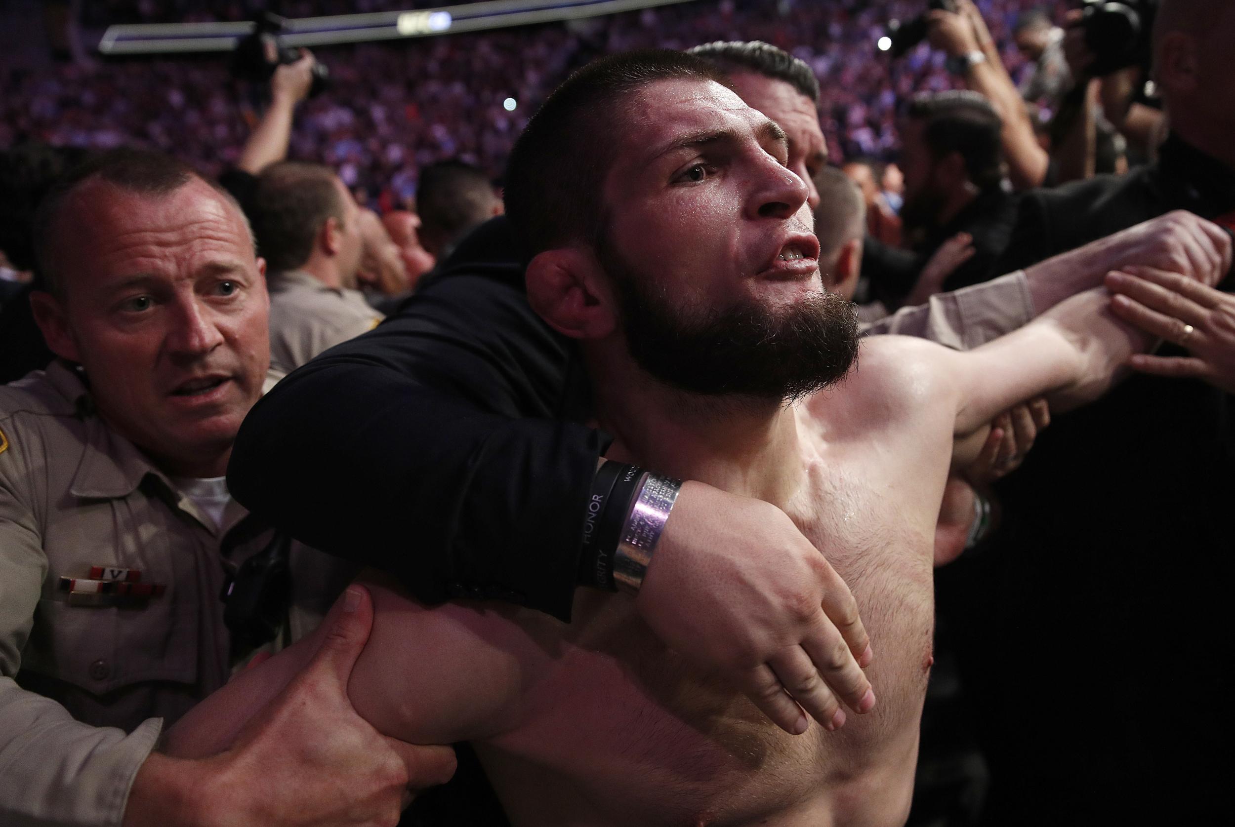 270611985 khabib nurmagomedov is held back outside of the cage after fighting conor mcgregor in a li 1